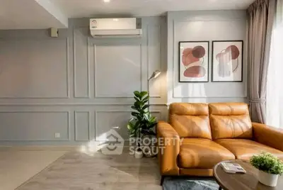 Stylish living room with leather sofa, modern decor, and natural light