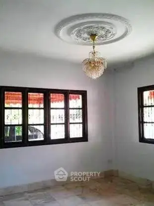 Elegant empty room with chandelier and large windows, perfect for customization.