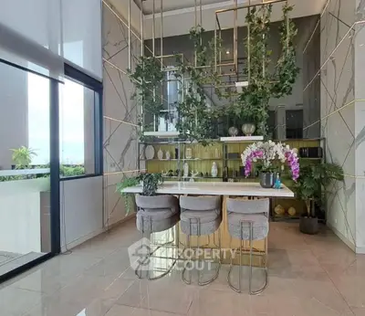 Luxurious modern kitchen with elegant bar seating and lush greenery accents.