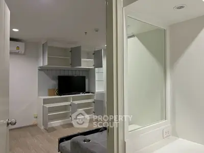 Modern living room with built-in shelves and TV, showcasing sleek design and neutral tones.