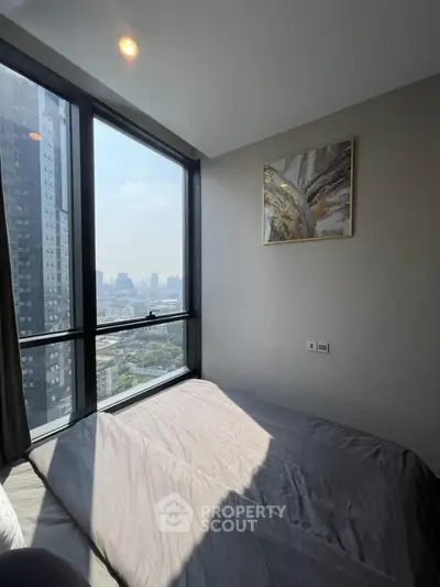 Modern bedroom with city view and large windows in high-rise apartment