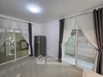 Spacious modern living area with sliding glass doors and elegant curtains