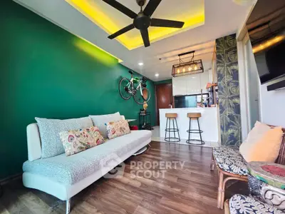 Stylish living room with modern decor, featuring a cozy sofa, bar stools, and a mounted bicycle on a vibrant green wall.