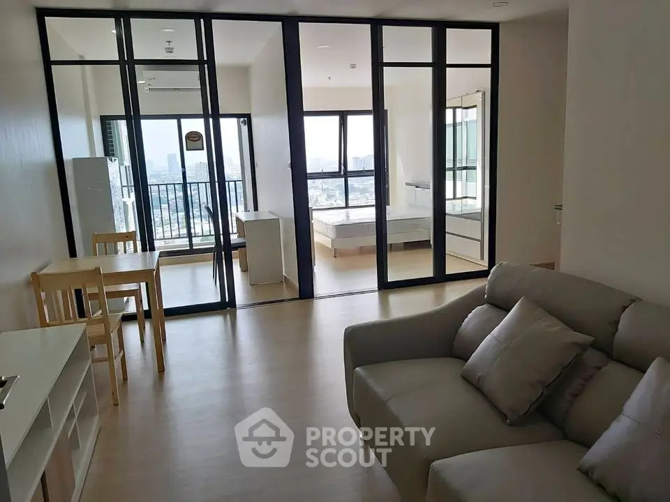 Modern open-plan living room with city view and balcony access