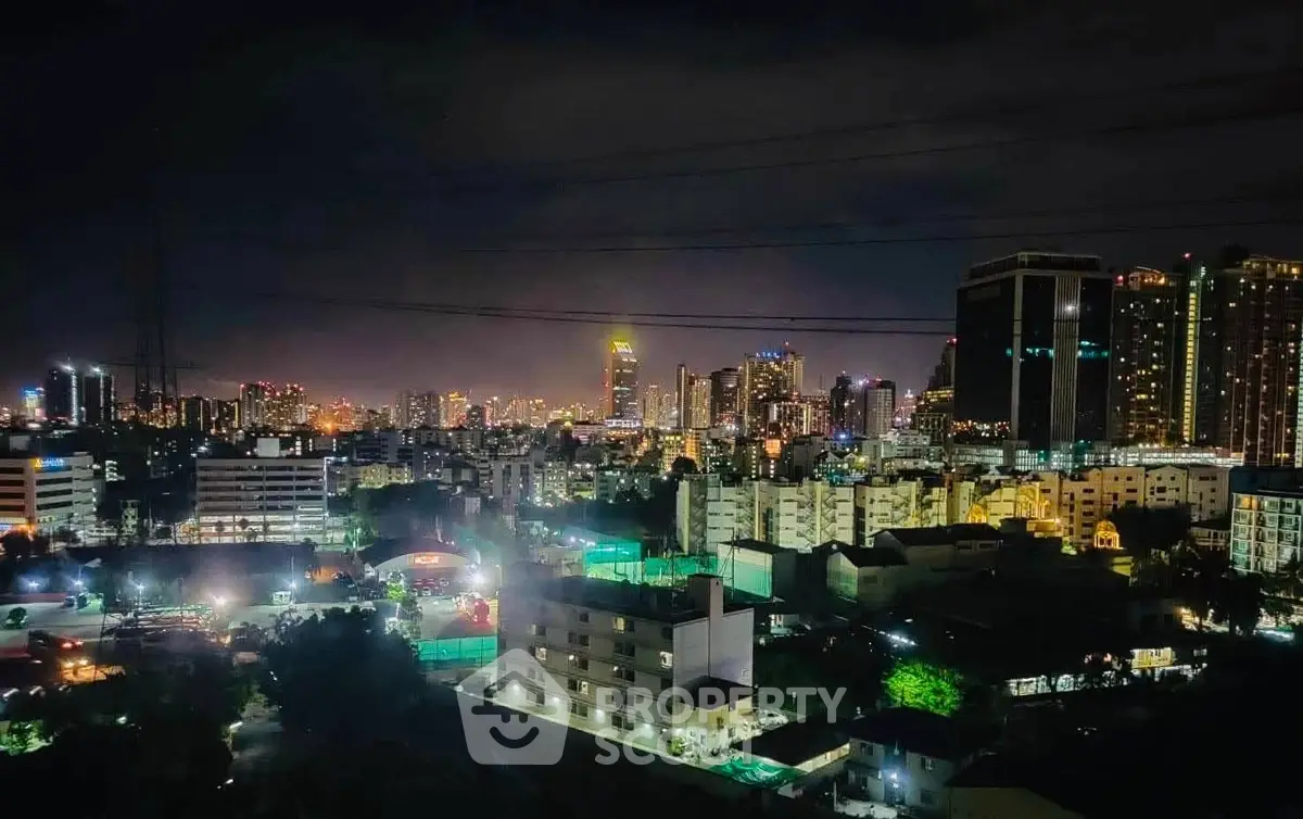 Stunning city skyline view at night with illuminated buildings and vibrant city lights.