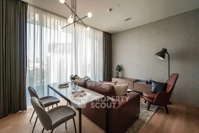 Elegant living room with modern furniture and large windows offering natural light.