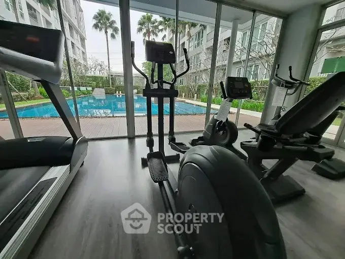 Modern gym with pool view in luxury apartment complex