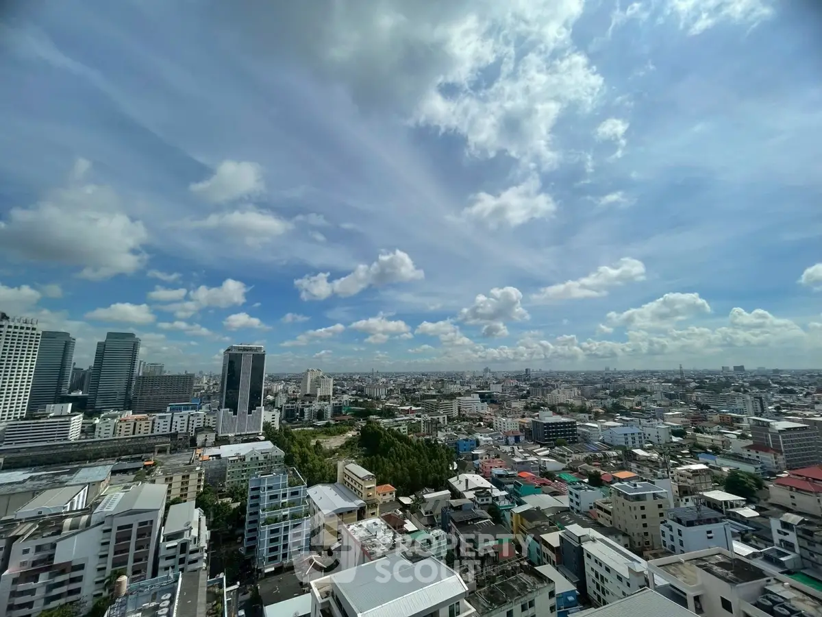 Stunning cityscape view from a high-rise building, showcasing urban skyline under a vibrant blue sky.