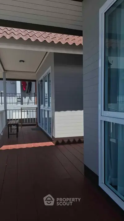 Spacious balcony with modern design and large windows in a contemporary home.