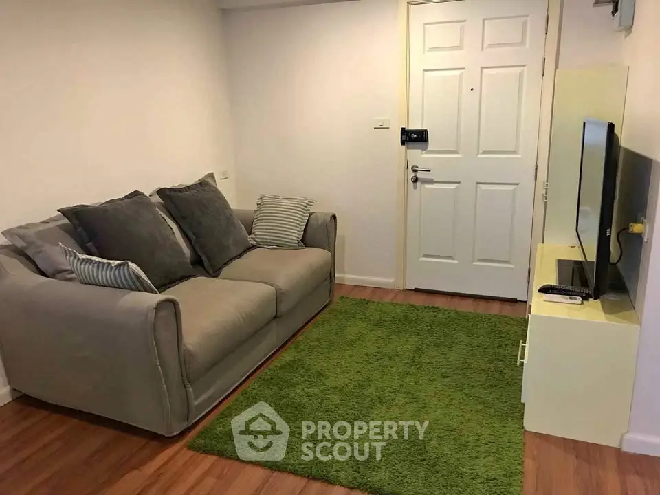 Cozy living room with modern sofa and TV setup, perfect for relaxation.