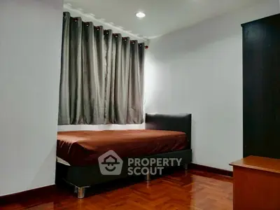 Cozy bedroom with wooden flooring and modern furnishings, ideal for restful nights.
