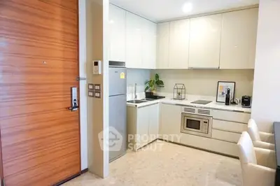 Modern kitchen with sleek cabinets and built-in appliances in a cozy apartment.