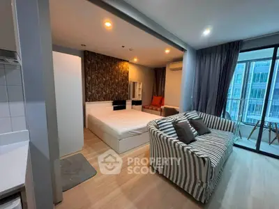 Modern studio apartment with stylish decor and large windows offering natural light.