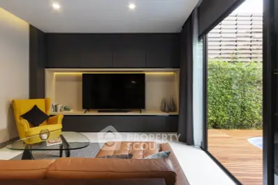 Modern living room with sleek design, large TV, and garden view through sliding glass doors.