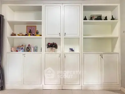 Elegant built-in white storage cabinets with decorative items in a modern living space.