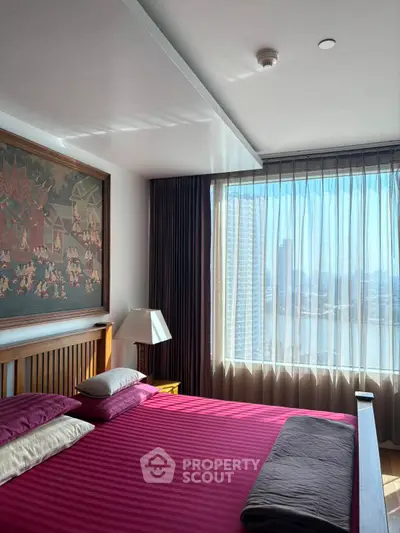 Elegant bedroom with large window offering stunning city view and stylish decor.