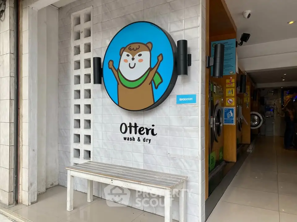 Charming laundromat entrance with playful otter logo and modern design.
