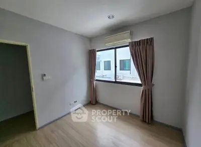 Spacious empty bedroom with large window and air conditioning unit.