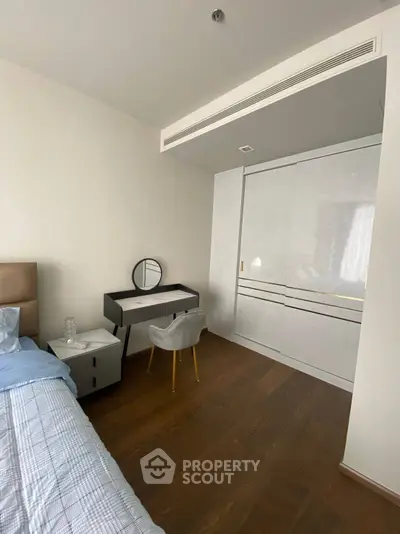 Modern bedroom with stylish furniture and wooden flooring