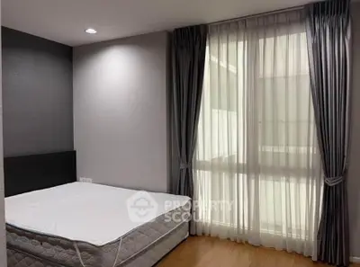 Spacious bedroom with large window and elegant curtains in modern apartment