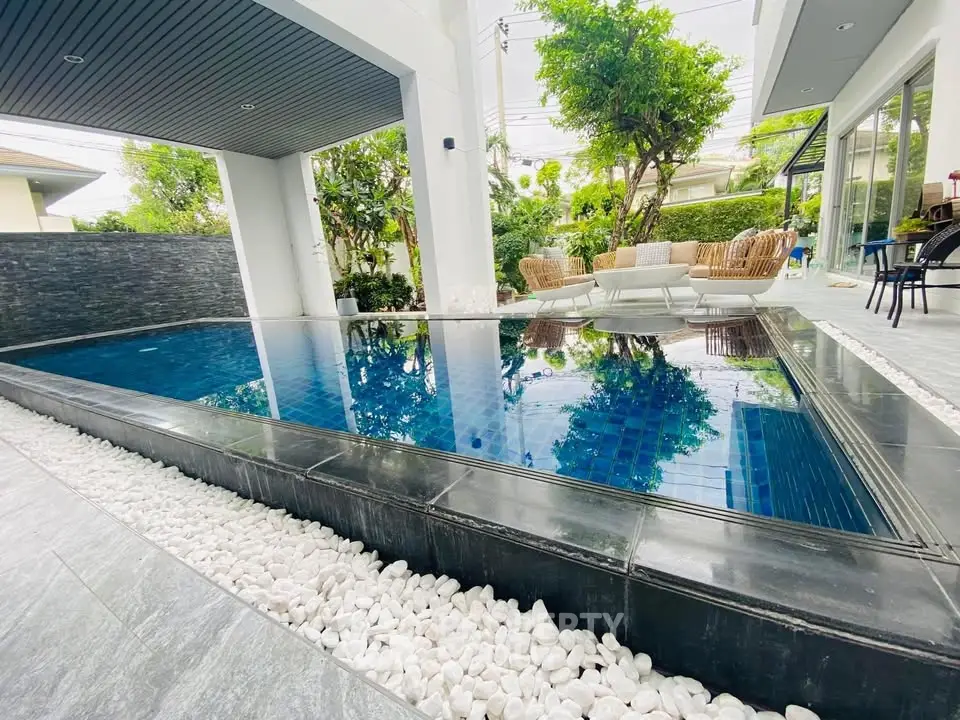 Luxurious modern home with private pool and stylish outdoor seating area, perfect for relaxation and entertainment.
