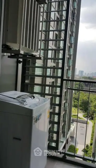 High-rise apartment balcony with washing machine and city view