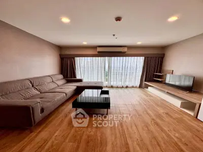 Spacious living room with modern furniture and large windows for natural light.
