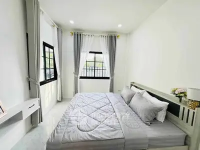 Bright and airy bedroom with modern decor and large windows for natural light.