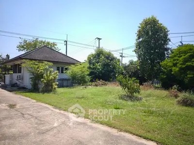 Charming single-story house with lush green garden and spacious driveway.