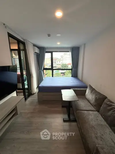 Modern studio apartment with large window and cozy furnishings