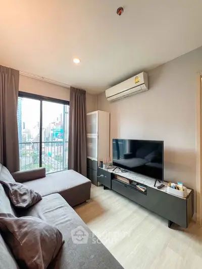 Modern living room with city view, featuring sleek furniture and large window for natural light.