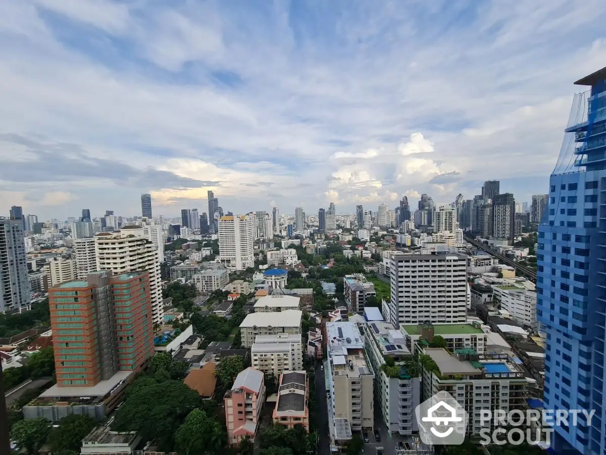 Stunning cityscape view from high-rise apartment showcasing urban skyline and lush greenery.