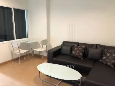 Modern living room with sleek black sofa and glass coffee table, perfect for stylish urban living.