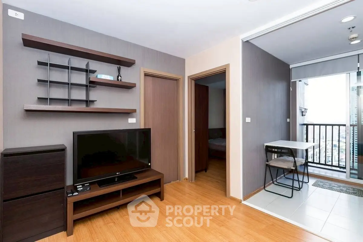 Modern living room with wooden flooring and balcony access in a stylish apartment.