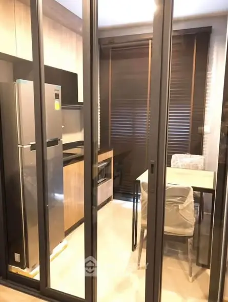 Modern kitchen with sleek appliances and dining area in a stylish apartment.
