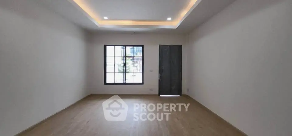 Spacious empty room with modern lighting and large window