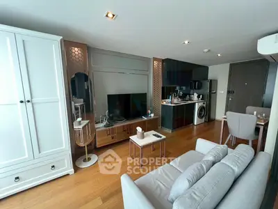 Modern living room with stylish furniture and open kitchen layout in a contemporary apartment.