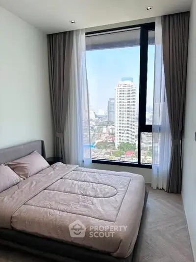 Modern bedroom with large window offering stunning city view, elegant decor and cozy ambiance.