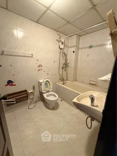 Spacious bathroom with bathtub and modern fixtures in a well-lit setting.