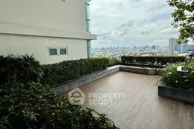 Stunning cityscape view from a spacious balcony with lush greenery.