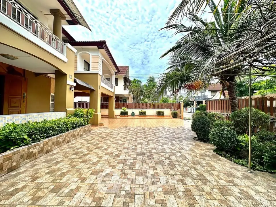 Spacious villa with lush garden and elegant entrance in a serene neighborhood.