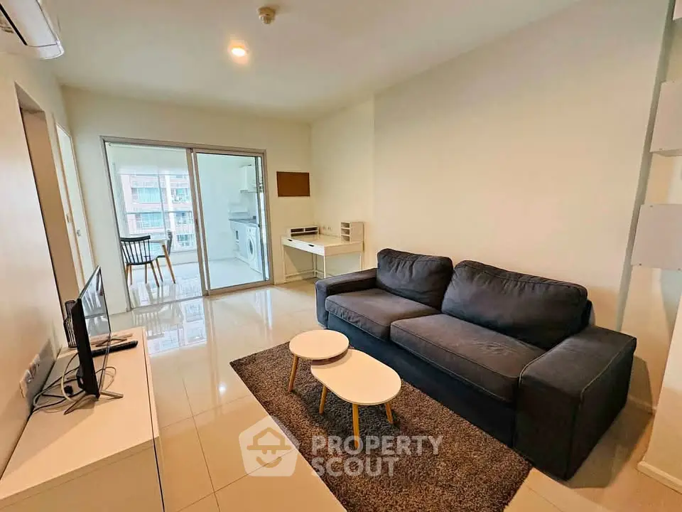 Modern living room with sleek furniture and balcony view in a stylish apartment.