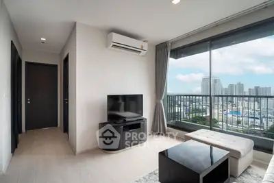 Modern living room with city view and balcony access in high-rise apartment.