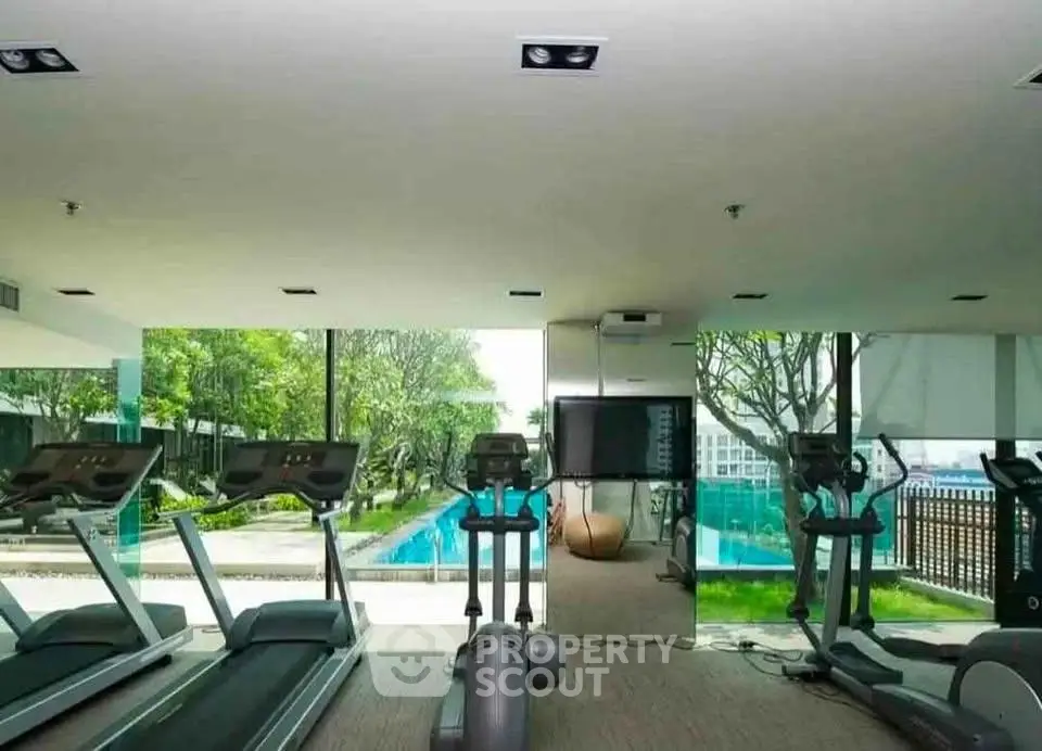 Luxurious gym with pool view in modern residential complex
