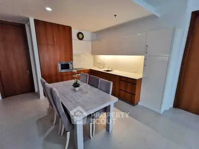 Modern kitchen with sleek cabinetry and dining area in contemporary apartment