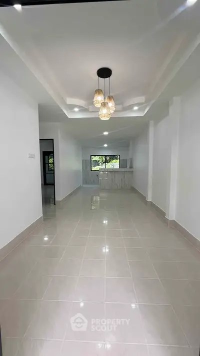 Spacious open layout living room with modern lighting and tiled flooring