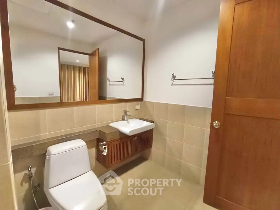 Modern bathroom with elegant wooden accents and large mirror
