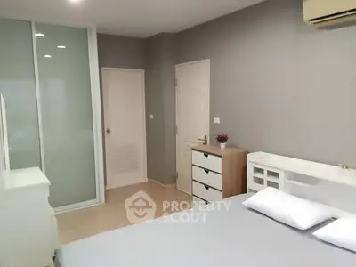 Spacious modern bedroom with sleek design and ample storage in a stylish apartment.