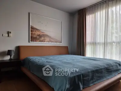 Cozy bedroom with modern decor and large window for natural light