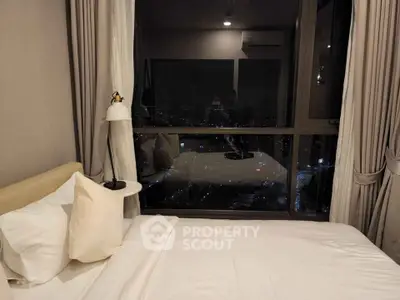 Luxurious bedroom with stunning city view through large window, elegant decor and cozy ambiance.